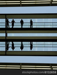 people in silhouette at a modern building