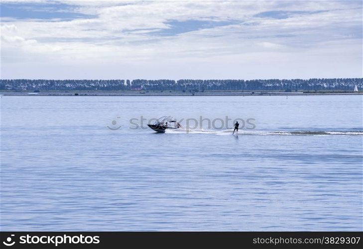 people in the boat and water ski behind it on the haringvliet in Holland