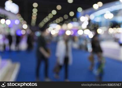 people in tradeshow exhibition hall building, blur background