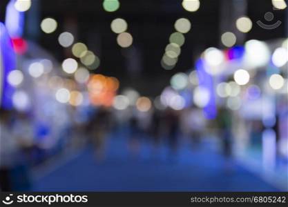 people in tradeshow exhibition hall building, blur background