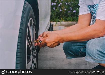 People inflating the tires of car parked