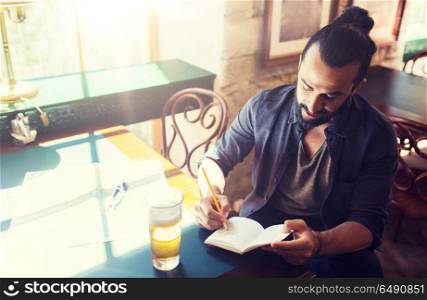 people, inspiration, freelance and leisure concept - man with beer writing to notebook at bar or pub. man with beer writing to notebook at bar or pub. man with beer writing to notebook at bar or pub