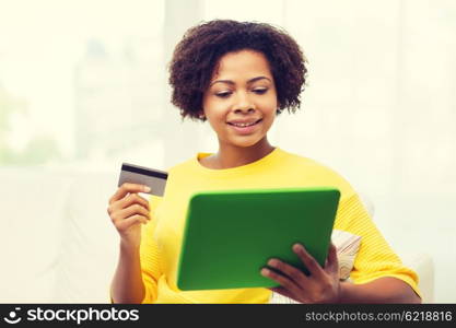 people, internet bank, online shopping, technology and e-money concept - happy african american young woman sitting on sofa with tablet pc computer and credit card at home