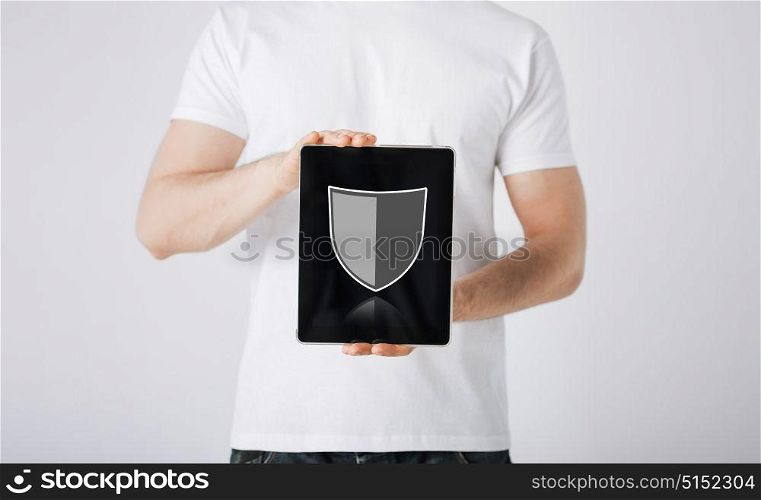 people, internet security and cyber protection concept - close up of man with virtual antivirus program shield icon on tablet pc computer screen over gray background. man with antivirus program icon on tablet pc