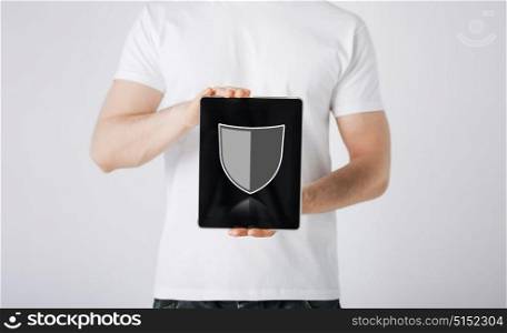 people, internet security and cyber protection concept - close up of man with virtual antivirus program shield icon on tablet pc computer screen over gray background. man with antivirus program icon on tablet pc