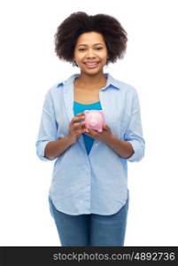 people, investment, saving and finances concept - happy afro american young woman with piggy bank