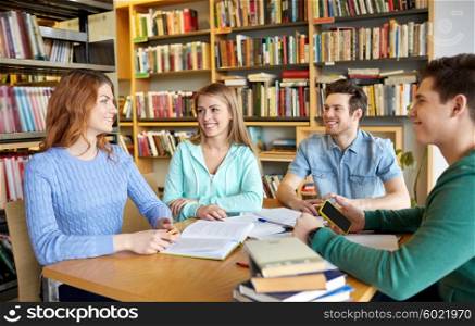 people, knowledge, education and school concept - group of happy students reading books and preparing to exam in library