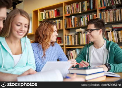 people, knowledge, education and school concept - group of happy students writing to notebooks in library