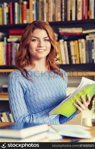 people, knowledge, education and school concept - happy student girl reading books in library