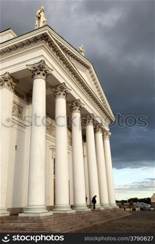 people leaving helsinki cathedral in the evening under dramatic sky