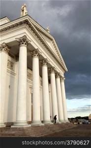 people leaving helsinki cathedral in the evening under dramatic sky