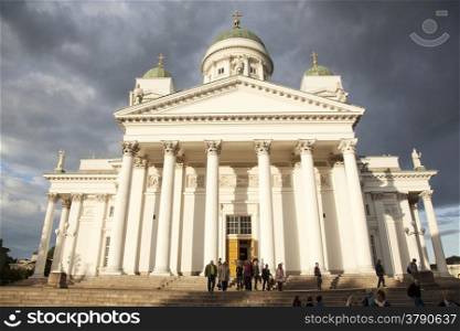 people leaving helsinki cathedral in the evening under threatening sky