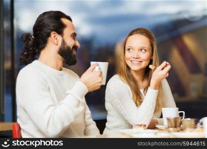 people, leisure and communication concept - happy couple meeting and drinking tea or coffee at cafe