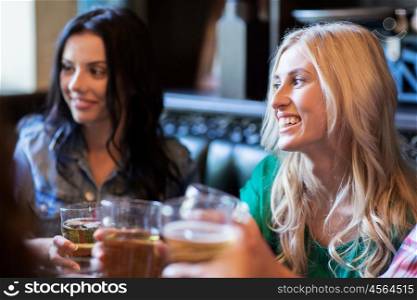 people, leisure and friendship concept - happy women meeting with friends and drinking beer at bar or pub