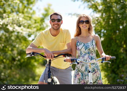 people, leisure and lifestyle concept - happy young couple with bicycles at country. happy couple with bicycles at country
