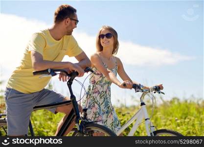 people, leisure and lifestyle concept - happy young couple with bicycles at country. happy couple with bicycles at country