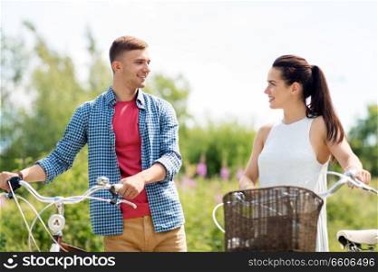 people, leisure and lifestyle concept - happy young couple with fixed gear bicycles in summer. happy couple with fixed gear bicycles in summer