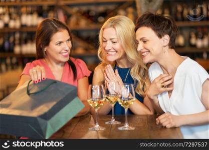 people, leisure and lifestyle concept - women with shopping bag at wine bar or restaurant. women with shopping bag at wine bar or restaurant