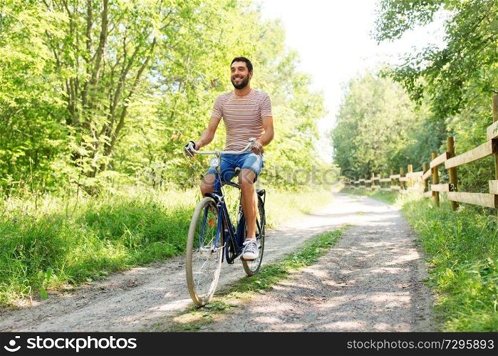 people, leisure and lifestyle - happy man riding fixie bicycle at summer park. man riding fixie bicycle at summer park