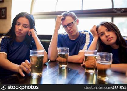 people, leisure and sport concept - happy friends or football fans drinking beer and watching soccer game or match at bar or pub