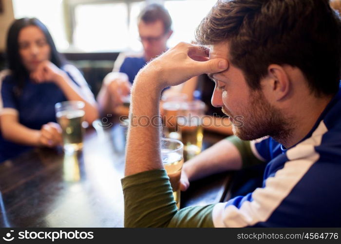 people, leisure and sport concept - happy friends or football fans drinking beer and watching soccer game or match at bar or pub