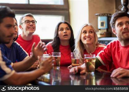 people, leisure and sport concept - happy friends or football fans drinking beer and watching soccer game or match at bar or pub