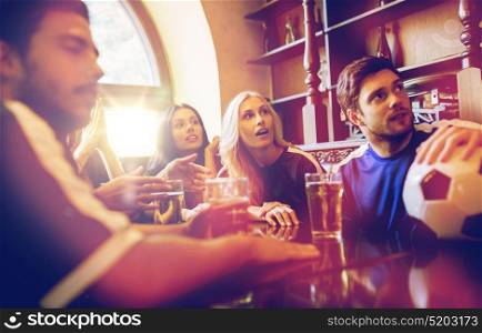 people, leisure and sport concept - happy friends or football fans drinking beer and watching soccer game or match at bar or pub. fans or friends watching football at sport bar