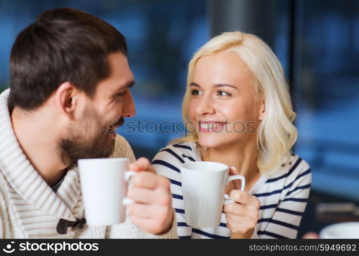 people, leisure, communication, eating and drinking concept - happy couple meeting and drinking tea or coffee at cafe