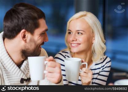 people, leisure, communication, eating and drinking concept - happy couple meeting and drinking tea or coffee at cafe