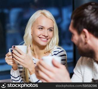 people, leisure, communication, eating and drinking concept - happy couple meeting and drinking tea or coffee at cafe