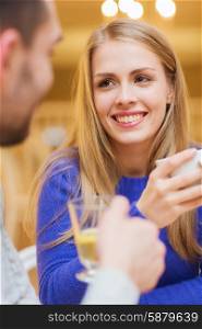 people, leisure, dating and communication concept - happy couple dating and drinking tea at cafe or restaurant