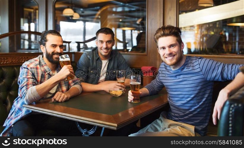 people, leisure, friendship and and bachelor party concept - happy male friends drinking beer at bar or pub