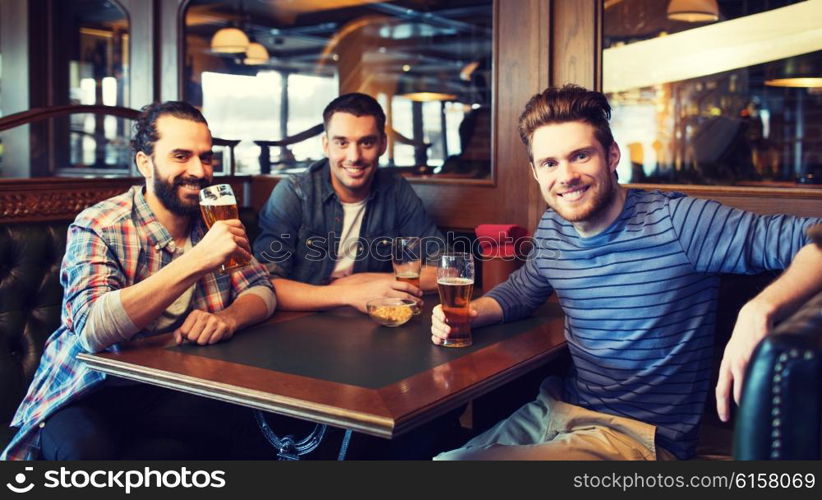 people, leisure, friendship and and bachelor party concept - happy male friends drinking beer at bar or pub