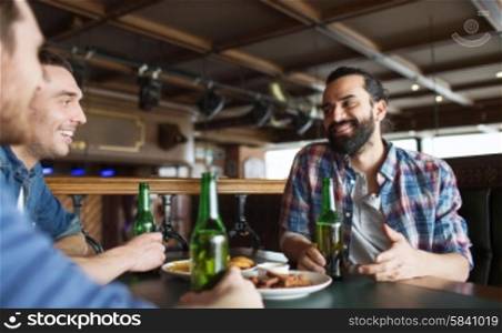 people, leisure, friendship and bachelor party concept - happy male friends drinking bottled beer and talking at bar or pub