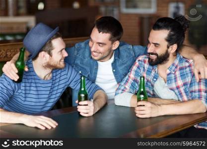 people, leisure, friendship and bachelor party concept - happy male friends drinking bottled beer and talking at bar or pub