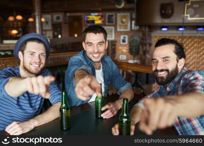 people, leisure, friendship and bachelor party concept - happy male friends drinking bottled beer and and pointing on you at bar or pub