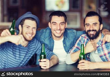 people, leisure, friendship and bachelor party concept - happy male friends drinking bottled beer and hugging at bar or pub
