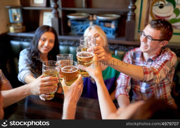 people, leisure, friendship and celebration concept - happy friends drinking draft beer and clinking glasses at bar or pub. happy friends drinking beer at bar or pub