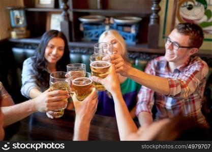 people, leisure, friendship and celebration concept - happy friends drinking draft beer and clinking glasses at bar or pub. happy friends drinking beer at bar or pub
