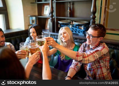 people, leisure, friendship and celebration concept - happy friends drinking draft beer and clinking glasses at bar or pub. happy friends drinking beer at bar or pub