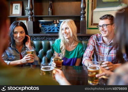 people, leisure, friendship and communication concept - happy friends drinking beer and talking at bar or pub. happy friends drinking beer at bar or pub