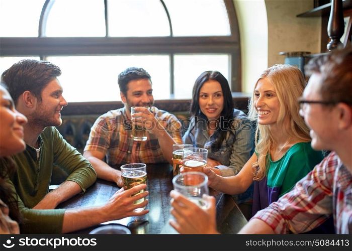 people, leisure, friendship and communication concept - happy friends drinking beer and talking at bar or pub. happy friends drinking beer at bar or pub. happy friends drinking beer at bar or pub