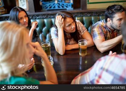 people, leisure, friendship and entertainment concept - friends drinking beer and watching sport game or football match at bar or pub