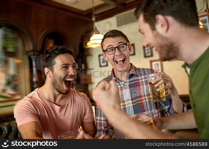 people, leisure, friendship and entertainment concept - happy football fans or male friends drinking beer and celebrating victory at bar or pub