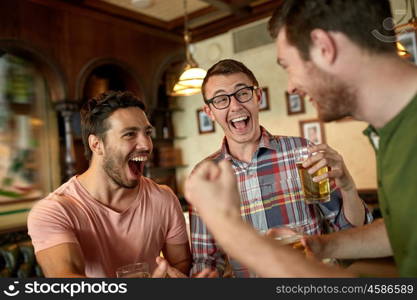 people, leisure, friendship and entertainment concept - happy football fans or male friends drinking beer and celebrating victory at bar or pub