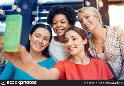 people, leisure, friendship and technology concept - happy young women taking selfie with smartphone. happy young women taking selfie with smartphone