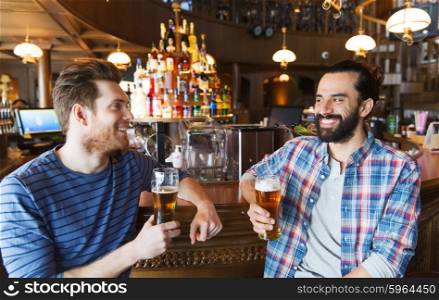 people, leisure, friendship, communication and bachelor party concept - happy male friends drinking beer and talking at bar or pub