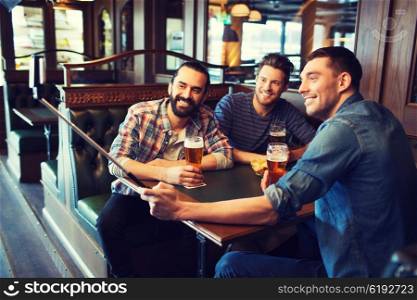 people, leisure, friendship, technology and bachelor party concept - happy male friends drinking beer and taking picture with smartphone selfie stick at bar or pub