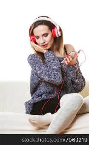 People leisure relax concept. Woman casual style red big headphones listening music mp3, sitting on couch at home relaxing
