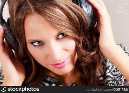 People leisure relax concept. Young woman in big headphones listening music mp3 relaxing at home